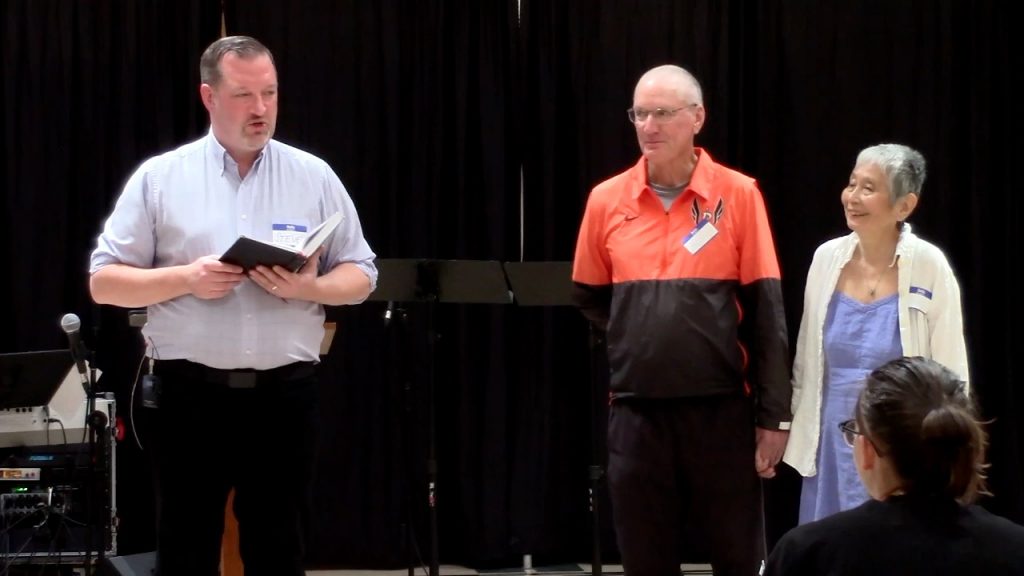 Pastor Steve stands next to Kevin and Sandy and invites the congregation to welcome them to the church as members.